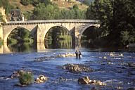 France: Aveyron, Gorges du Lot, two men fishing in river.