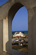 Ghana: Elmina (Central Region), Elmina castle, also known as St. George’s Castle (built 1486), as seen through arched window at St. Jago fort (built 1666)