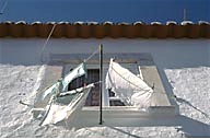 Portugal: Estremoz, window with clothes on clothesline, with red tile roof above