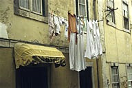 Portugal: Lisbon, Bairro Alto, hanging laundry above doorway and below windows