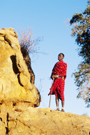 Maasai moran standing on rock, Ewaso Nyiro River, Shaba National Reserve