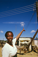 Liz M’Wara, TechnoServe staff from Nairobi, pointing to electric wires in Nyala.