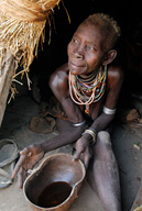 Older woman in her hut offering coffee in a Karo tribal village, 