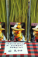 Italy: Piedmont, Langhe, tagilatelle pasta with porcini mushrooms for sale with portrait of vendor