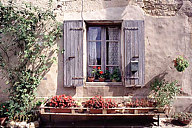 France: Grignan, window with potted geraniums
