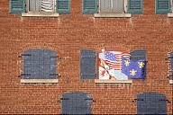 Missouri: Ste. Genevieve, brick wall with shuttered windows and faux trompe l’oeil flags