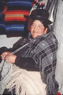 Peru: Puno, street vendor knitting with alpaca yarn