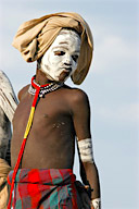 Nyangatom village dance, boy in body paint wearing traditional beaded jewelry