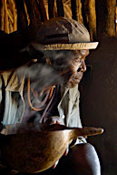 Hamar family homestead, old man drinking coffee from a gourd in a hut